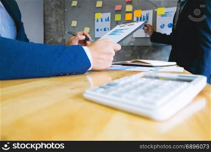 two business executives analyzing data paper at workplace