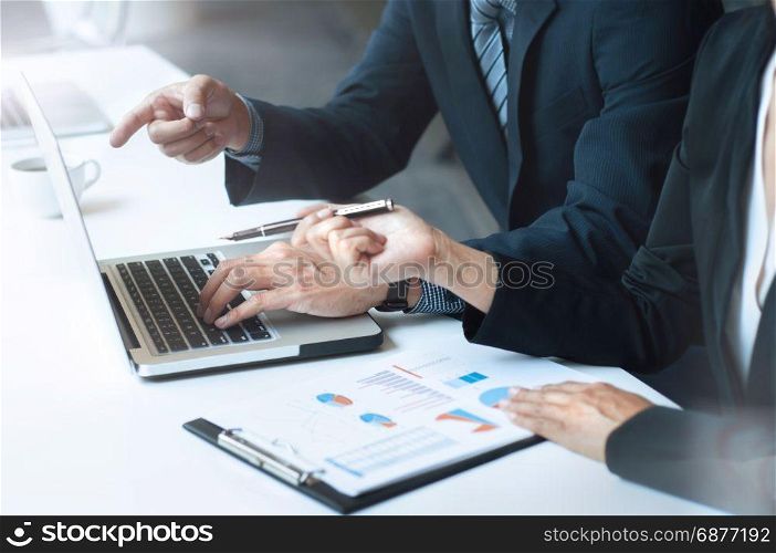 two business executives sitting at desk discussing sales performance in contemporary office