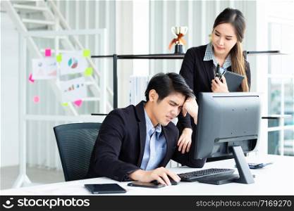 Two Business men are stressed at work With businesswoman partners helping to make positive recommendations working with computer on wooden table and ideas at meeting in office background.
