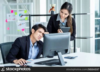 Two Business men are stressed at work With businesswoman partners helping to make positive recommendations working with computer on wooden table and ideas at meeting in office background.
