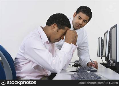 Two business men at desk in front of computer