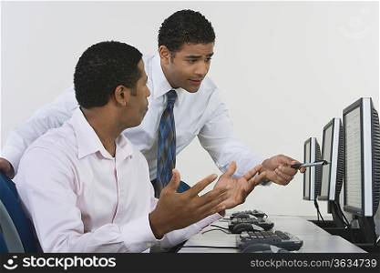 Two business men discussing in front of computer