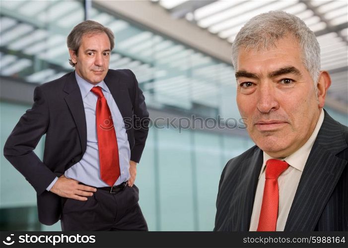two business men portrait standing in a modern building