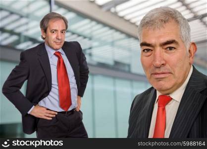 two business men portrait standing in a modern building