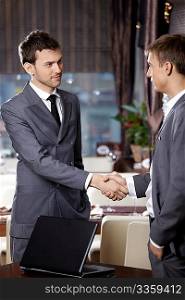 Two business men shake hands each other at a meeting at restaurant