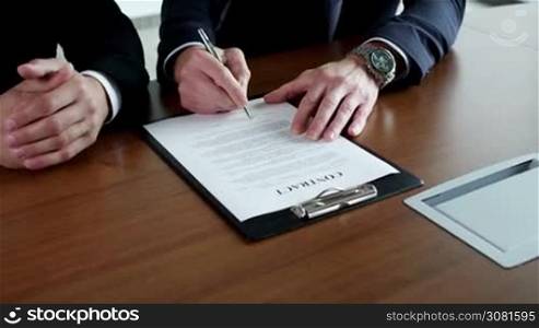 Two business men signing a contract close up view