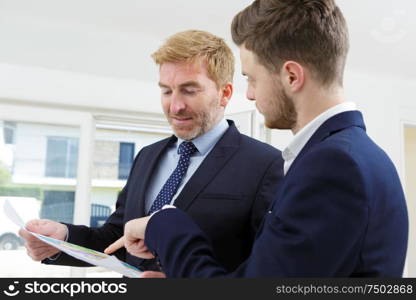 two business partners discussing a project in a white office