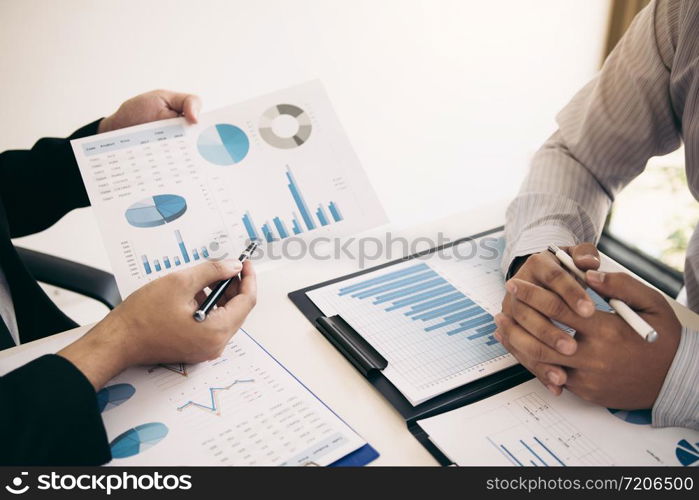 Two business partnership coworkers analysis strategy and gesturing with discussing a financial planning graph and company budget during a budget meeting in office room.