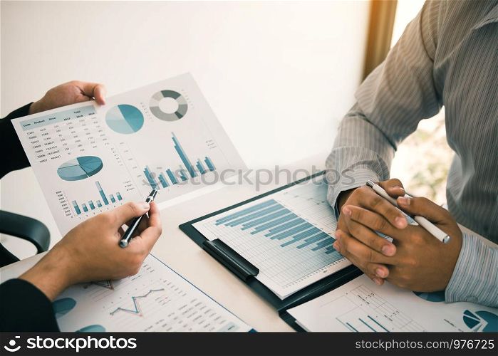 Two business partnership coworkers analysis strategy and gesturing with discussing a financial planning graph and company budget during a budget meeting in office room.