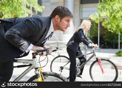 Two business people racing on the bicycle showing competition