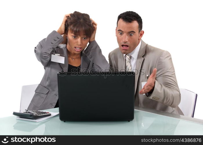 Two business people shocked by laptop