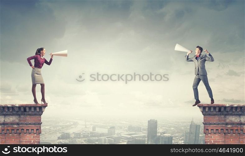 Two business people shouting in megaphones at each other. Business conflict