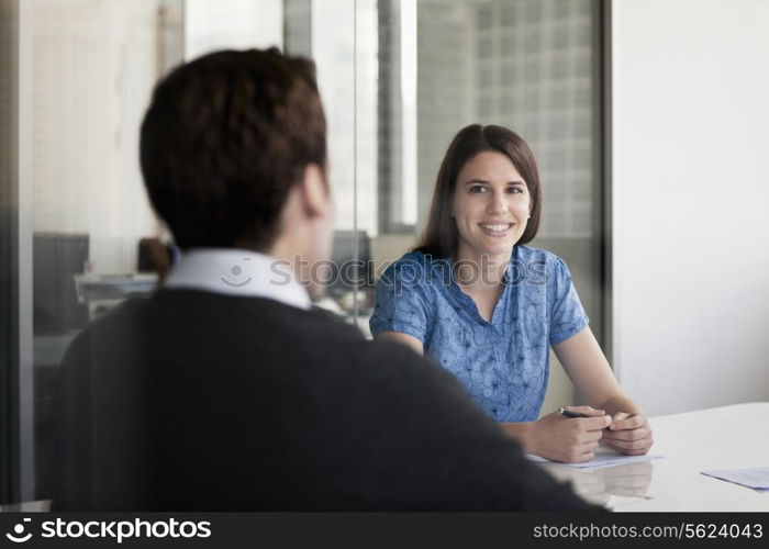 Two business people sitting at a conference table and discussing during a business meeting