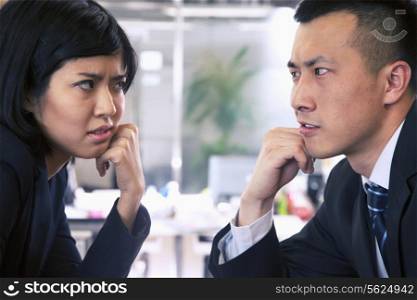 Two Business people staring at each other across a table