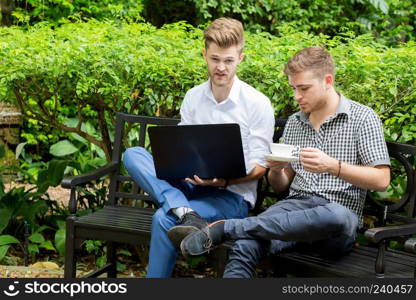 Two business people use of the notebook computer at outdoor