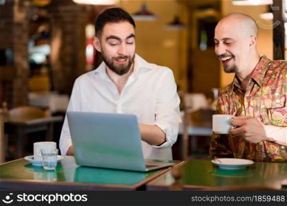 Two business people using a laptop during a meeting at a coffee shop. Business concept.