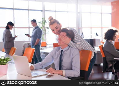 two business people using laptop preparing for next meeting and discussing ideas with colleagues in the background