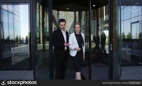 Two business people walking outdoors office building