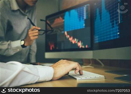Two business stock brokers stress and looking at monitors displaying financial information.