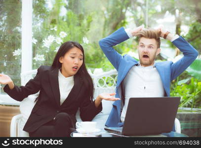 Two business surprised looking at laptop computer with shocked, businessman and businesswoman contract with excited in meeting teamwork.