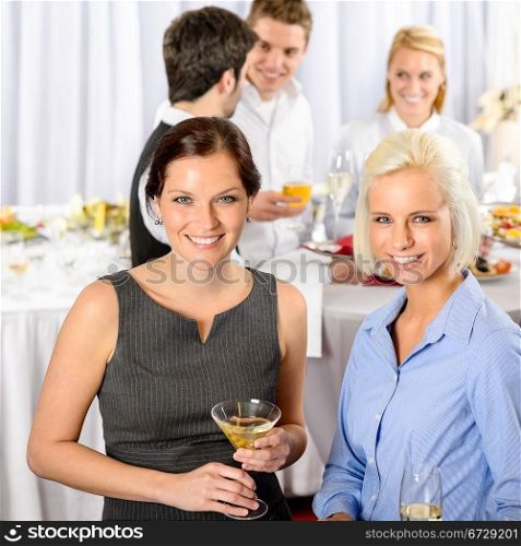Two business woman smiling at catering buffet company meeting