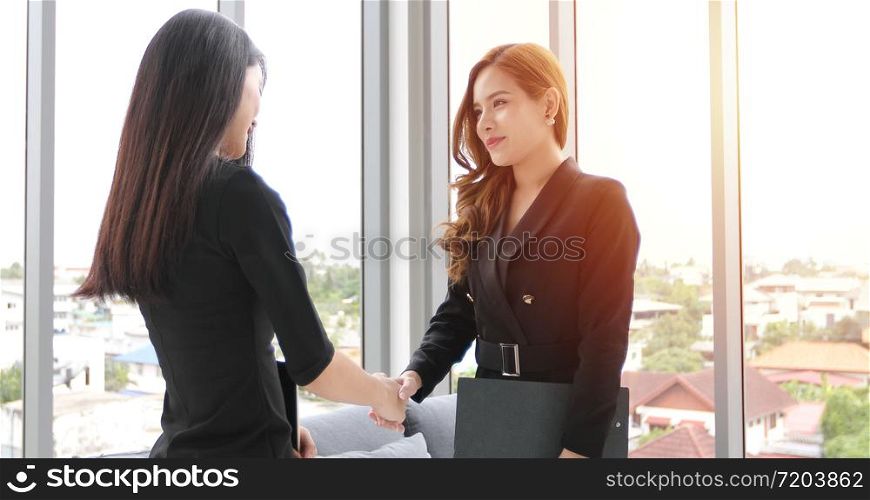 Two Business women handshake their agreement to sign contract