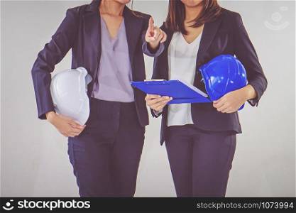 Two business women industrial engineers helmets with a tablet in hands