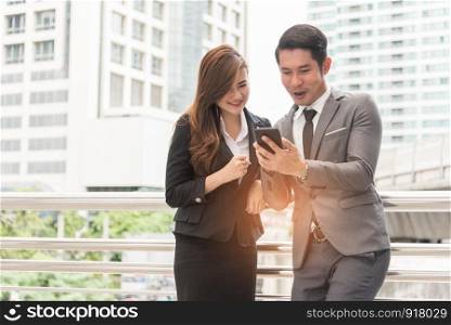 Two businessman and woman enjoy using mobile phone. Relax time and Happiness concept.