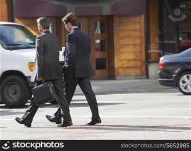 Two Businessman Chatting Whilst Crossing Street