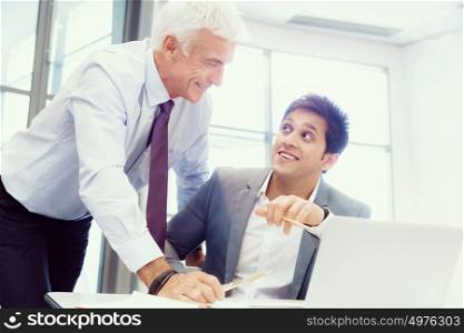 Two businessman in office having discussion in front of computer. Ready to help