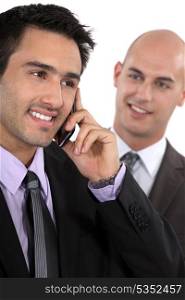Two businessman receiving a call