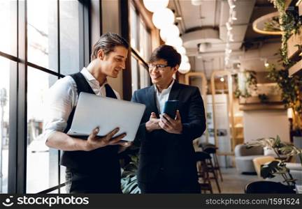 Two Businessman Working Together on Computer Laptop in Creative Workplace. Happy Business Partnership People