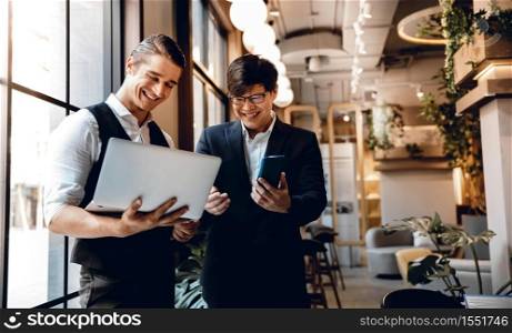 Two Businessman Working Together on Computer Laptop in Creative Workplace. Happy Business People
