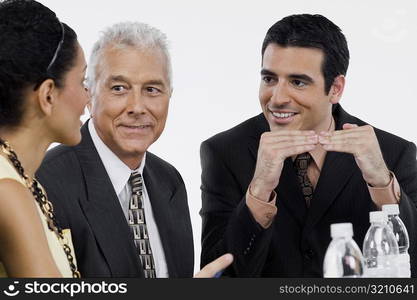 Two businessmen and a businesswoman at a meeting in a conference room