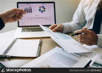 Two businessmen are jointly analyzing the financial budget and cost of the company together.