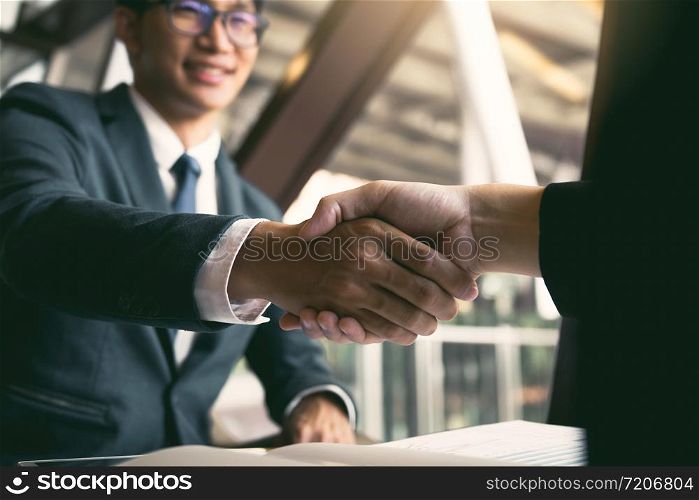 Two businessmen are talking and making deals on business operations and agreeing by shaking hands in the office.