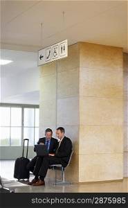 Two Businessmen at Airport Using Laptop