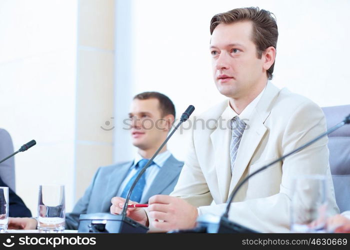 Two businessmen at meeting. Image of two businessmen sitting at table at conference