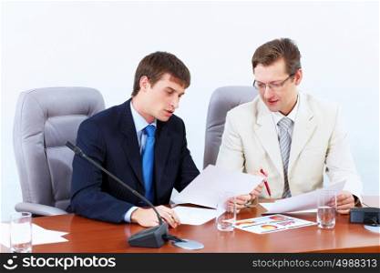 Two businessmen at meeting. Image of two businessmen sitting at table at conference
