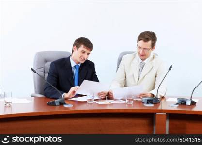 Two businessmen at meeting. Image of two businessmen sitting at table at conference