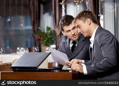 Two businessmen at restaurant discuss the document