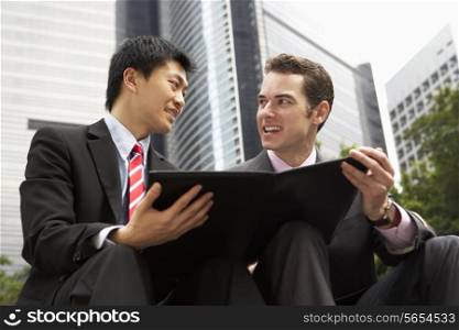 Two Businessmen Discussing Document Outside Office