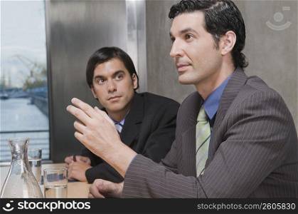 Two businessmen discussing in a conference room