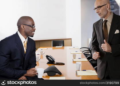 Two businessmen discussing in a conference room