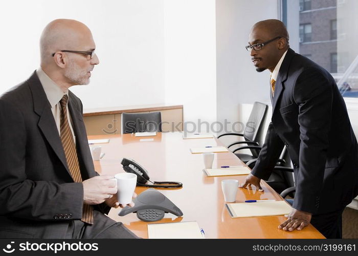 Two businessmen discussing in a conference room