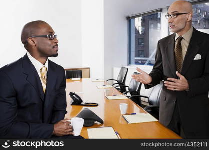 Two businessmen discussing in a conference room