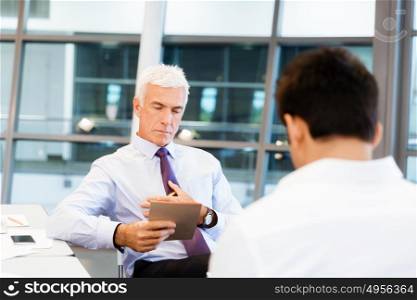 Two businessmen during interview in office. Doing business is about people