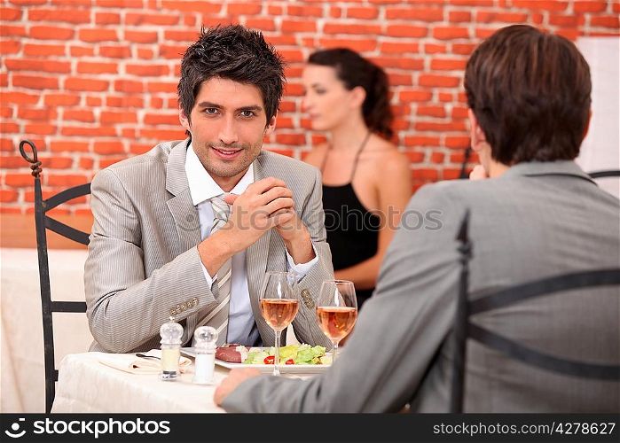 two businessmen eating in a restaurant