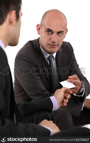 Two businessmen exchanging cards