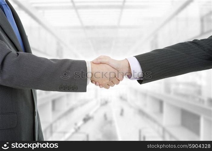 Two businessmen handshake at the office